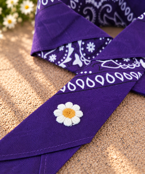 Close-up van het embleem van een wit madeliefje op de Daisy Purple kinderbandana