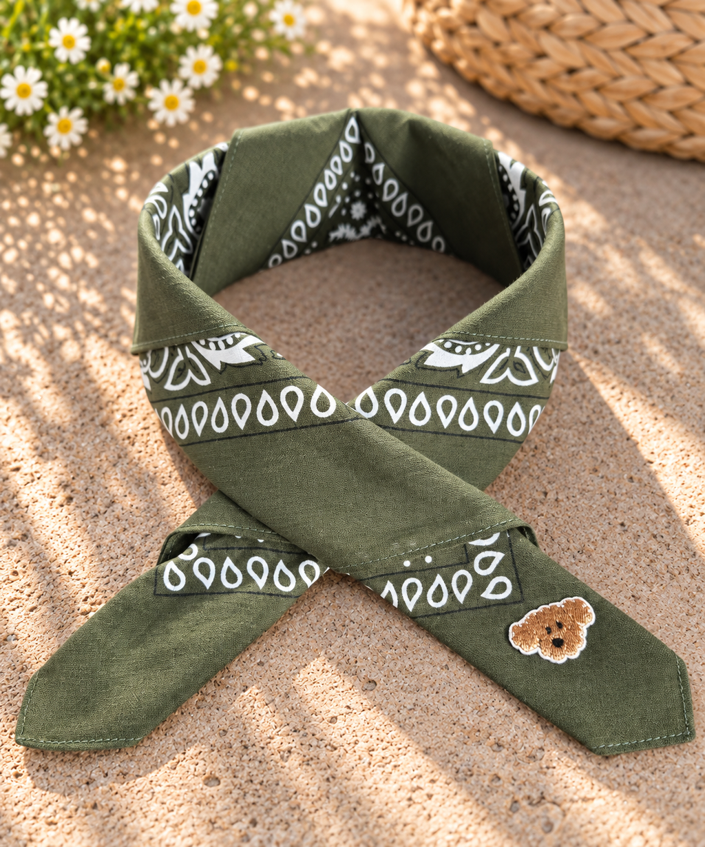 Doggy Green kinderbandana in donkergroene paisley, opgevouwen met een embleem van een bruin hondje op de punt