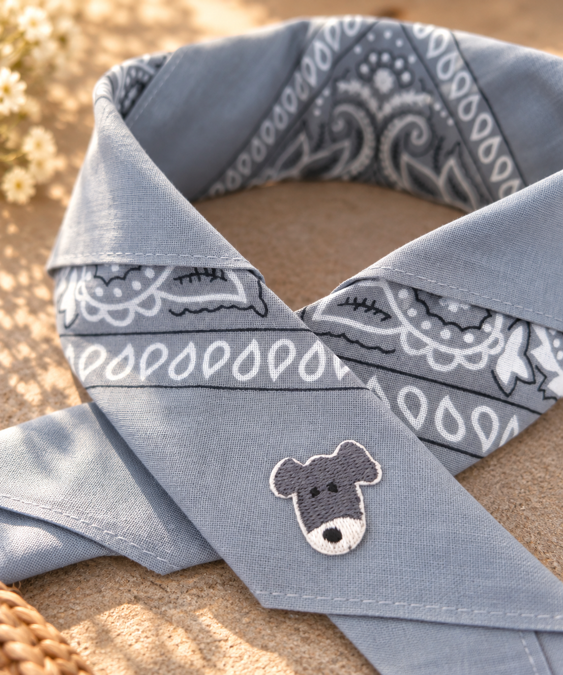 Close-up van het embleem van een grijs-wit hondje op de Doggy Grey kinderbandana