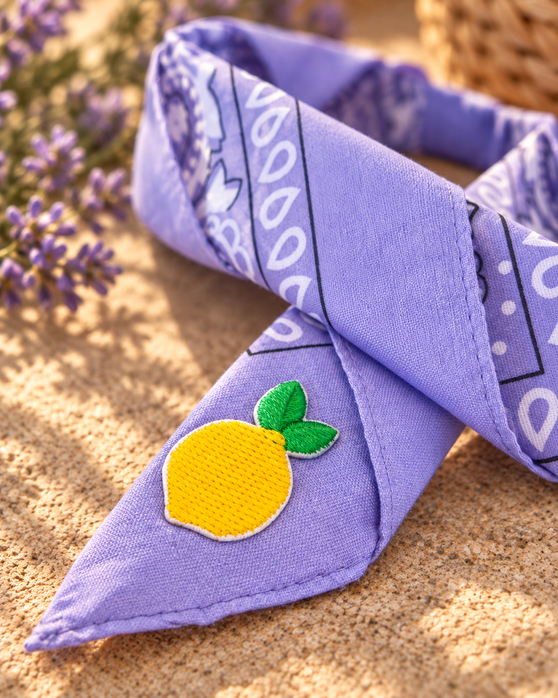 Close-up van het embleem van een gele citroen op de Lemon Lilac kinderbandana