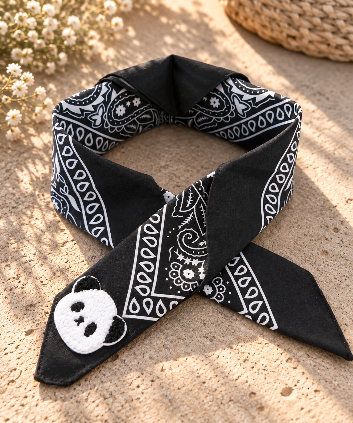 Panda Black kinderbandana in zwarte paisley, opgevouwen met een embleem van een panda op de punt