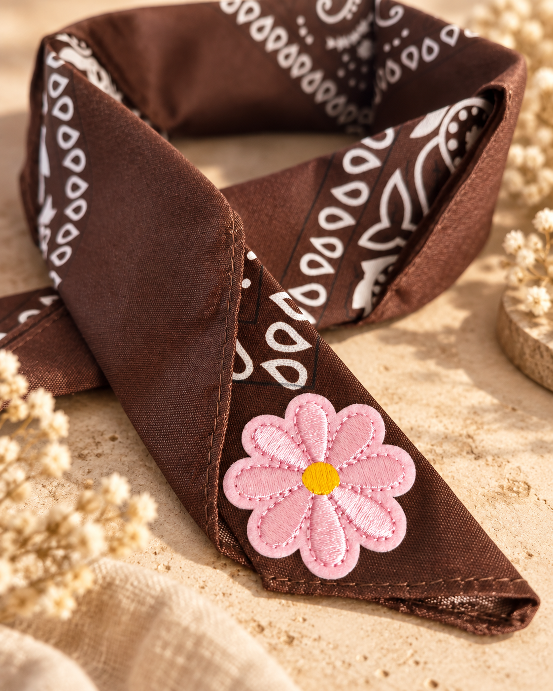 Close-up van het embleem van een roze bloem op de Pink Daisy Brown kinderbandana