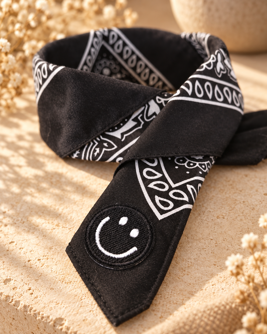 Close-up van het embleem van een zwart-witte smiley op de Smiley Black kinderbandana