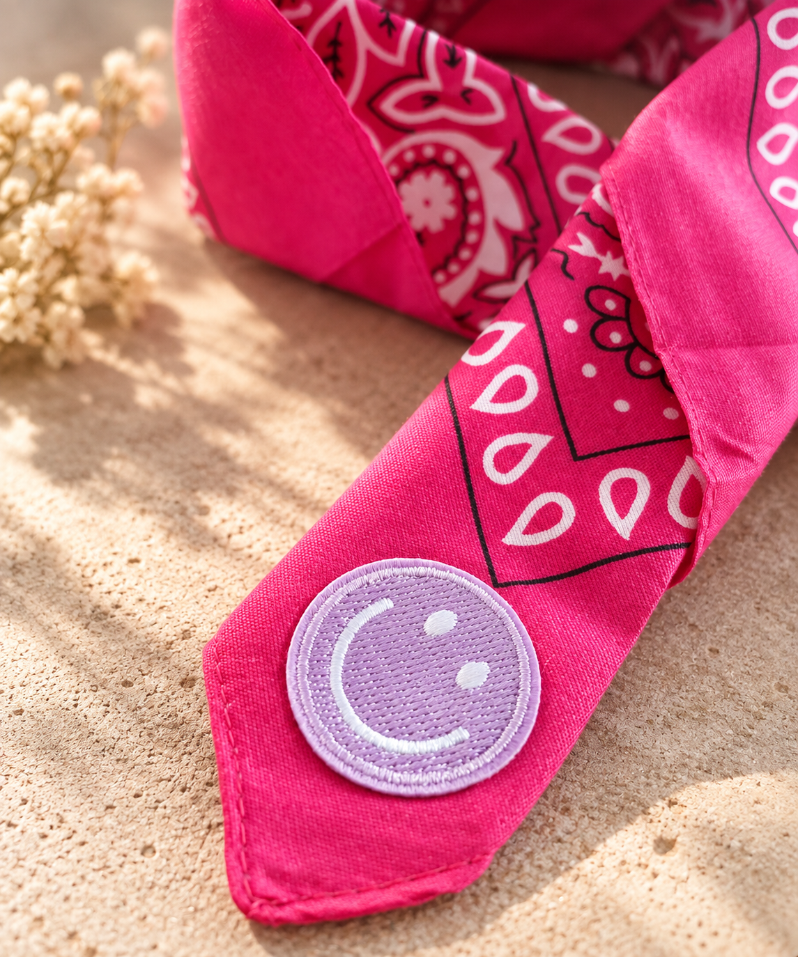 Close-up van het embleem van een lila smiley op de Smiley Fuchsia kinderbandana