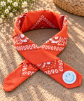 Smiley Orange kinderbandana in oranje paisley, opgevouwen met een embleem van een lichtblauwe smiley op de punt