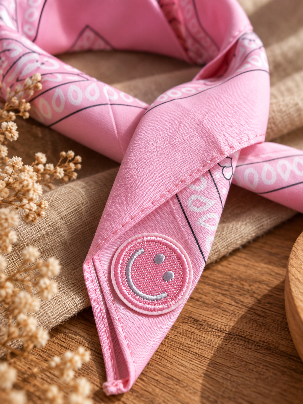Close-up van het embleem van een roze smiley op de Smiley Pink kinderbandana