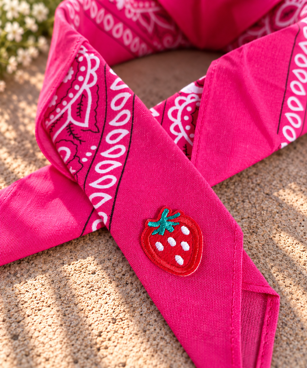 Close-up van het embleem van een rode aardbei op de Strawberry Fuchsia kinderbandana