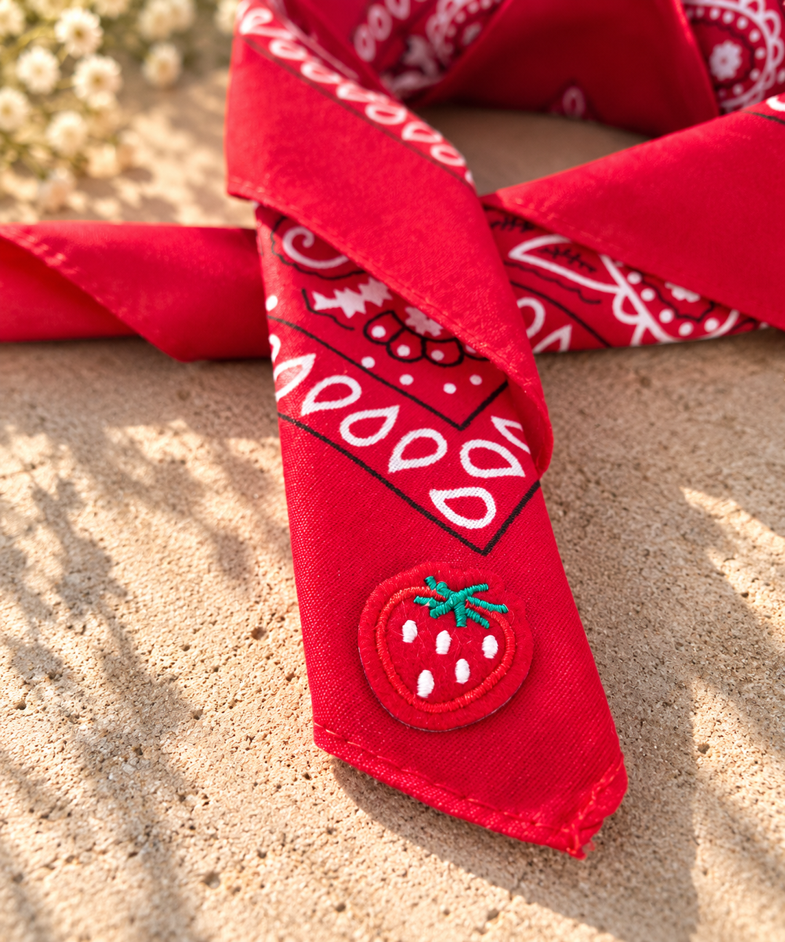 Close-up van het embleem van een rode aardbei op de Strawberry Red kinderbandana