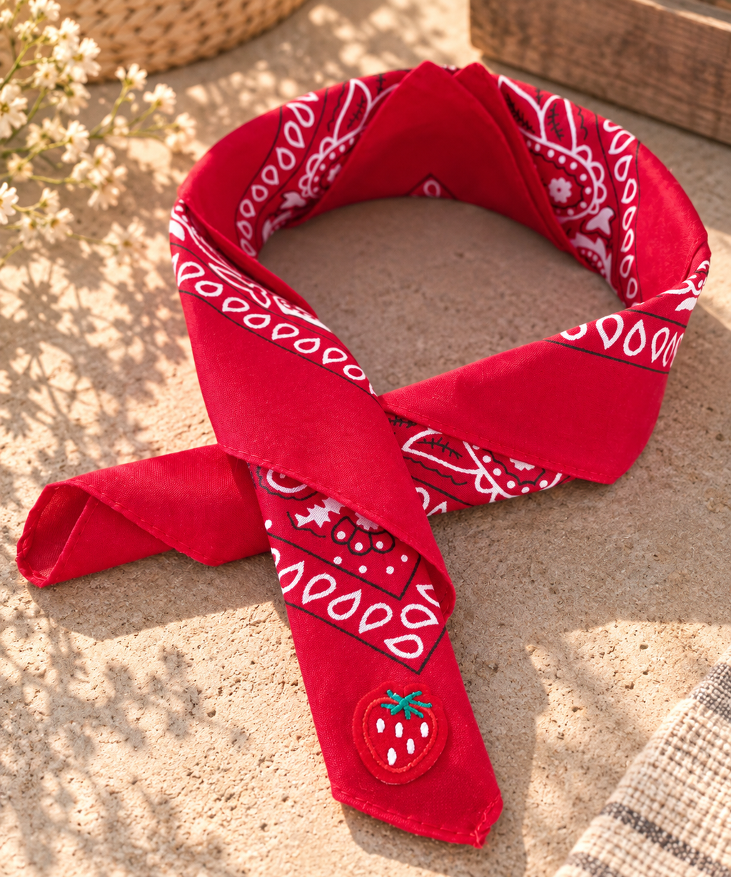 Strawberry Red kinderbandana in rode paisley, opgevouwen met een embleem van een rode aardbei op de punt