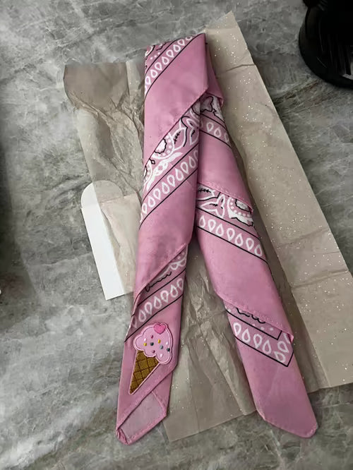 Roze Tiny Ties bandana met ijsje-embleem naast het geopende pakket, klantfoto bij de Google review van D Shaaban